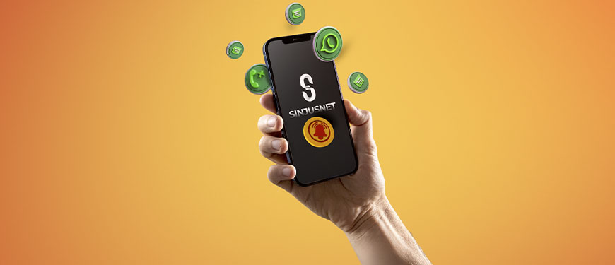 Mão segura um celular com a tela exibindo o logotipo do Sinjusnet, informativo do SINJUS-MG. Ao redor do aparelho, flutuam ícones 3D do WhatsApp, de notificações e mensagens, sobre um fundo em degradê laranja.