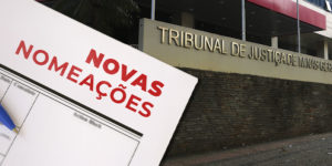 A imagem mostra ao fundo a fachada do TJMG, acompanhada de uma representação de documento com a inscrição “Novas Nomeações”.