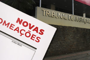 A imagem mostra ao fundo a fachada do TJMG, acompanhada de uma representação de documento com a inscrição “Novas Nomeações”.