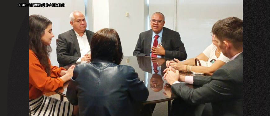 Grupo de representantes de Federações de Sindicatos em mesa de reunião no CNJ. Conteúdo textual: Resolução 481/22 - Fenajud, Fenajufe e Assejus buscam CNJ para debater o teletrabalho.