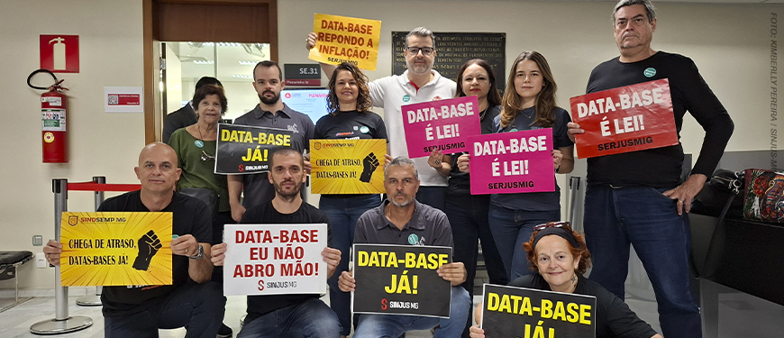 A imagem mostra um grupo de servidoras e servidores mobilizados em ambiente interno, segurando cartazes com mensagens como “DATA-BASE JÁ!”, “DATA-BASE É LEI!”, “DATA-BASE EU NÃO ABRO MÃO!” e “DATA-BASE REPONDO A INFLAÇÃO!”. No topo, aparece a editoria “AVANÇO” e, em destaque, o texto: “Data-Base 2025 é aprovada na FFO; votação no Plenário pode acontecer nesta quinta-feira.” A cena reforça o clima de mobilização e pressão pela recomposição inflacionária e pela aprovação definitiva da data-base.