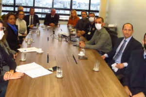 Foto de uma mesa de reunião retangular onde estão sentados de lado a lado os membros que compõem o Grupo de Trabalho do Assédio Moral e Sexual no TJMG.