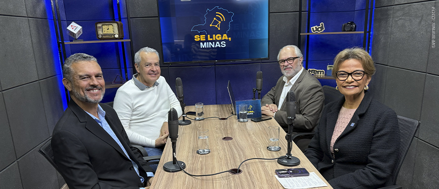 Imagem acessível: A imagem divulga o mais recente podcast do Se Liga, Minas. Na foto, mostra quatro pessoas em um estúdio, sentadas ao redor de uma mesa com microfones. Ao fundo, uma TV exibe o logotipo do podcast. O texto destaca: “Novo episódio do Se Liga, Minas traz debate sobre comunicação e o futuro do rádio”.