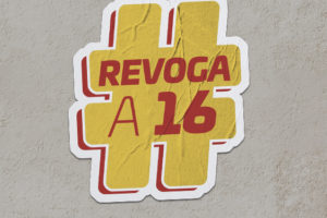 Montagem digital de um adesivo com a mensagem #REVOGAA16 sobre uma parede, o adesivo é tem cor de fundo amarelo com o texto em vermelho.