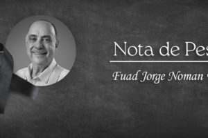 A imagem apresenta a nota de pesar pelo falecimento de Fuad Jorge Noman Filho. O fundo é escuro, transmitindo sobriedade e respeito, com um laço preto — símbolo tradicional de luto — em destaque. Há uma fotografia em preto e branco de Fuad, sorridente, acompanhada do texto “Nota de Pesar” seguido de seu nome completo