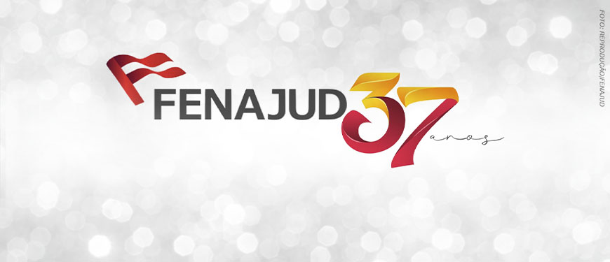 Imagem de celebração do aniversário da Fenajud, com fundo cinza claro em efeito desfocado, com pontos de luz que lembram brilho. No centro, está o logotipo da Fenajud, com um símbolo de bandeira vermelha à esquerda e a palavra “FENAJUD” em letras maiúsculas escuras. Ao lado, em destaque, aparece o número “37” em grande tamanho, com um degradê em tons de amarelo, laranja e vermelho, seguido da palavra “anos” em estilo manuscrito.