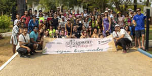 A imagem mostra os filiados e os diretores do SINJUS-MG posando juntos ao ar livre, em um ambiente cercado por vegetação. Elas estão em frente a uma placa que diz 33º Passeio Ecológico, Agosto 2024, Sejam bem-vindos SINJUS MG. As pessoas estão sorrindo e algumas usam óculos de sol e chapéus.