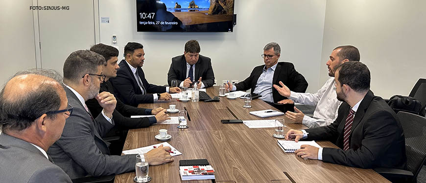 Fotografia da reunião com diretores do TJMG, representantes do Sinjus, Serjusmig, estão em volta de uma mesa, sentados