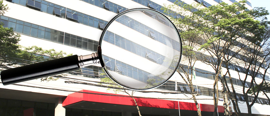 Foto do TJMG com uma lupa por cima, focando em detalhes da fachada do prédio.