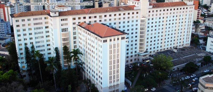 Vista aérea da Santa Casa de Misericórdia de Belo Horizonte, o prédio tem diversos blocos e muitos andares, a construção tem a pintura na cor azul com detalhes em branco. O telhado é em cerâmica.