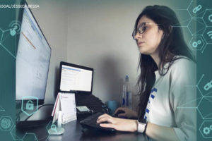 Foto de uma mulher de pele clara de cabelos pretos e longos usando blusa branca e óculos de grau usando o computador em seu home office. Aplicado sobre a foto ícones que remetem a tecnologia e comunicação em tons de azul.
