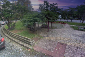 Foto da Praça Milton Campos, no bairro Serra, ao entardecer, há carros passando na rua ao lado, mas não há pessoas ocupando o local.