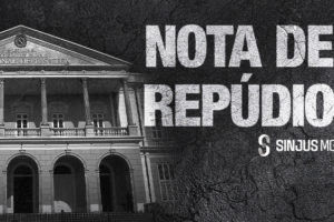 Imagem acessível: A imagem possui fundo escuro em preto e branco e textura áspera. Na parte superior, em letras grandes e com aparência desgastada, lê-se: “NOTA DE REPÚDIO”. Logo abaixo, dentro de uma faixa branca, está escrito: “SINJUS-MG repudia ações do TJPA contra manifestações sindicais”. Na base da imagem centralizada, aparece a fachada do Tribunal de Justiça do Estado do Pará (TJPA). No rodapé, aparece o logotipo do SINJUS-MG.