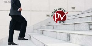 Foto de uma escada e um homem com enquadramento do peito para baixo usando terno preto subindo a escadaria. Há também uma marca da Promoção Vertical 2020.