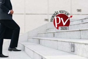 Foto de uma escada e um homem com enquadramento do peito para baixo usando terno preto subindo a escadaria. Há também uma marca da Promoção Vertical 2020.