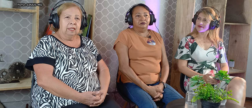 Há 3 mulheres sentadas no estúdio do SINJUS-MG, Maria Abadia de Souza (diretora de Finanças do Sisipsemg) , Antonieta Dorledo, presidente do Sindicato dos Servidores do Instituto de Previdência do Estado de Minas Gerais (Sisipsemg) e secretária da Mulher da Central dos Sindicatos Brasileiros (CSB) e Cristiane Sampaio, diretora Administrativa do SINJUS e coordenadora do Núcleo das Mulheres (NM).