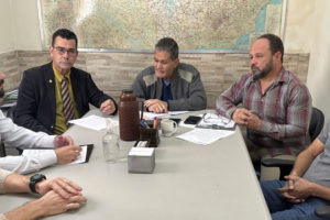 Foto em que estão sentados ao redor de uma mesa o deputado federal Padre João (PT/MG), o deputado estadual Leleco Pimentel (PT) e os diretores do SINJUS Alexandre Pires, Felipe Rodrigues e Alex Aguiar.