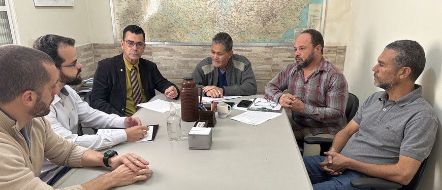 Foto em que estão sentados ao redor de uma mesa o deputado federal Padre João (PT/MG), o deputado estadual Leleco Pimentel (PT) e os diretores do SINJUS Alexandre Pires, Felipe Rodrigues e Alex Aguiar.