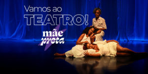Ao fundo, há uma cena da peça "Mãe Preta", com três mulheres negras em roupas brancas sobre o palco iluminado por luz azul: uma está em pé, com expressão serena, enquanto as outras duas estão sentadas e deitadas apoiando-se umas nas outras. No topo do cartaz lê-se: “Vamos ao TEATRO!”. Abaixo, o título da peça: “Mãe Preta”, com a palavra "preta" sobre uma estrela roxa.