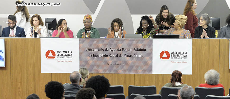 Mesa diretiva do Lançamento da Agenda por um Estatuto da Igualdade Racial de Minas Gerais, na ALMG. Na mesa estão deputadas e representantes do movimento negro de Minas Gerais.