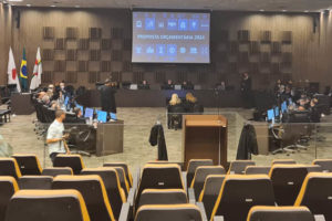 Auditório do Órgão Especial, os desembargadores estão reunidos nas laterais de uma mesa diretiva, ao fundo desta há um grande painel de led, onde é possível ler "Proposta Orçamentária 2024".