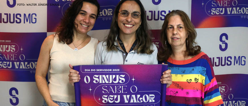 Fotografia contendo filiados do Sinjus segurando a placa com a logo tema do mês do servidor que se lê, "O Sinjus sabe seu valor".