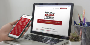 A imagem possui o fundo em tons de cinza mostrando uma pessoa segurando um celular diante de um notebook. Ambos exibem o hotsite do SINJUS sobre a Reforma Administrativa, com o título “Reaja à Farsa da Reforma Administrativa”.