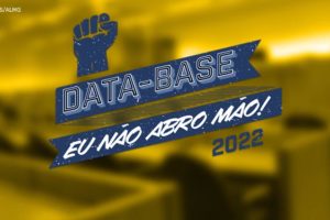 Em destaque a arte do SINJUS com os dizeres em azul escuro “Data-Base. Eu não abro mão! 2022” e ao fundo, com filtro amarelo, está uma foto de um plenário de comissão da Assembleia Legislativa de Minas Gerais.