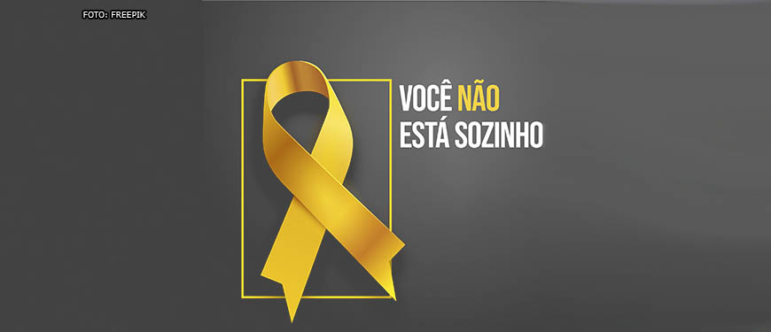 ustração de uma fita amarela que representa a prevenção ao suícidio, ao lado a frase "Você não está sozinho".