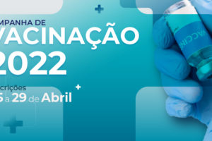 Card em tons de azul, à direita temos uma foto de uma mão segurando uma ampola enchendo uma seringa de vacinação, ao centro da imagem temos o conteúdo textual "Campanha de Vacinação 2022. Inscrições de 25 a 29 de Abril".