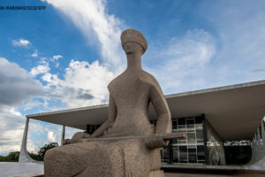 Fachada do Edifício do Supremo Tribunal Federal em Brasília, no primeiro plano há uma grande escultura da deusa Themis da Justiça.
