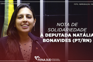 Deputada federal Natalia Bonavides (PT/RN) durante discurso em tribuna da Câmara dos Deputados. Mulher de pele clara, cabelo preto liso e comprido, usando um blazer azul escuro e uma camisa clara com bolinha escuras.