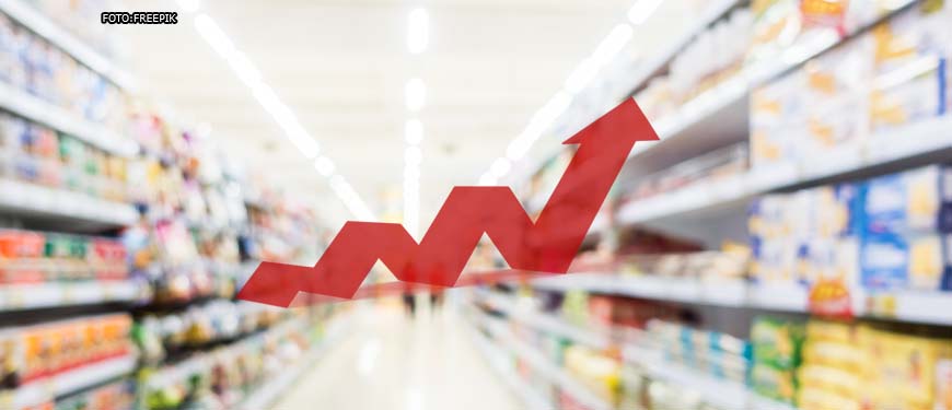 ao fundo e desfocado está um corredor de supermercado com prateleiras cheias dos dois lados e ao centro uma arte com um gráfico de linha vermelho indicando elevação de preços.