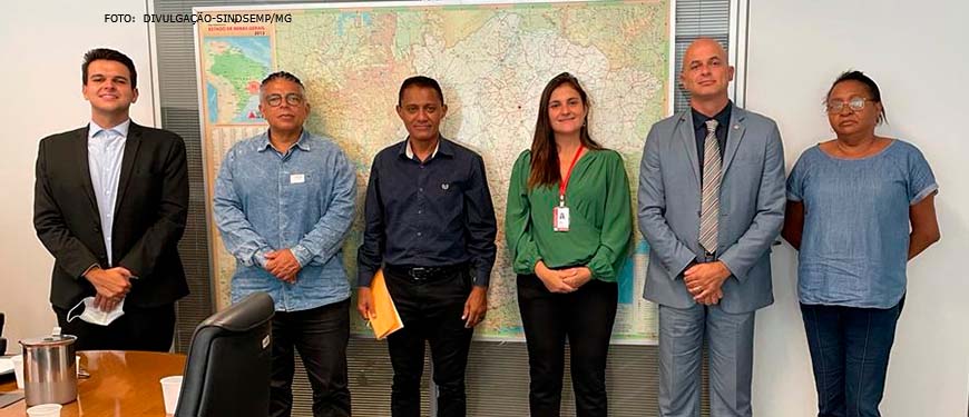 Imagem Acessível: Em uma fila estão dispostos Geraldo Henrique, diretor político do SINDPÚBLICOS-MG; Eduardo Maia, do Ministério Público; Jonas Araujo, Tribunal de Justiça; Luiza Campos, Presidenta do IPSEMG; Antonieta Dorledo, do SISIPSEMG e Pedro William diretor de políticas e saúde do IPSEMG, todos com trajes sociais em uma sala de reuniões. Conteúdo Textual: Saúde. Diretor do SINJUS toma posse no Conselho de Beneficiários do IPSEMG.