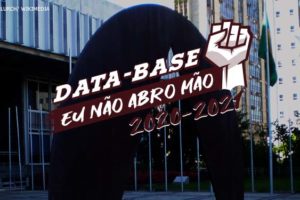 #ImagemAcessível Fachada da Assembleia Legislativa de Minas Gerais. Sobre a foto, há uma ilustração de um punho cerrado para o alto com o conteúdo textual escrito na cor branca: Data-Base, eu não abro mão! 2020-2021.