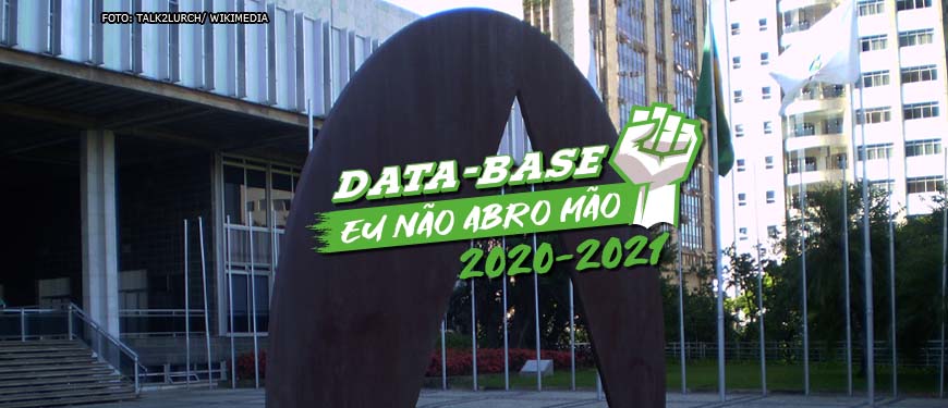 Fachada da Assembleia Legislativa de Minas Gerais. Sobre a foto, há uma ilustração de um punho cerrado para o alto nas cores branco e verde com o conteúdo textual escrito na cor branca: Data-Base, eu não abro mão! 2020-2021.