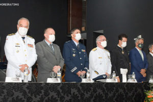 #ImagemAcessível: Foto da solenidade realizada no Clube dos Oficiais da Polícia Militar de Minas Gerais para a posse da nova direção do TJMMG : Desembargador e coronel PM Rúbio Paulino Coelho, desembargador Fernando Antônio Nogueira Galvão da Rocha, desembargador e coronel PM Sócrates Edgard dos Anjos, desembargador e coronel PM James Ferreira Santos e o desembargador e coronel BM Osmar Duarte Marcelino Respectivamente enfileirados atrás de uma grande mesa.