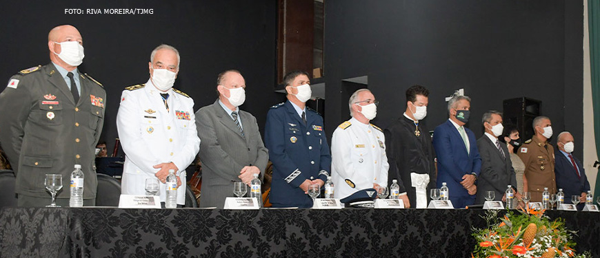 #ImagemAcessível: Foto da solenidade realizada no Clube dos Oficiais da Polícia Militar de Minas Gerais para a posse da nova direção do TJMMG : Desembargador e coronel PM Rúbio Paulino Coelho, desembargador Fernando Antônio Nogueira Galvão da Rocha, desembargador e coronel PM Sócrates Edgard dos Anjos, desembargador e coronel PM James Ferreira Santos e o desembargador e coronel BM Osmar Duarte Marcelino Respectivamente enfileirados atrás de uma grande mesa.