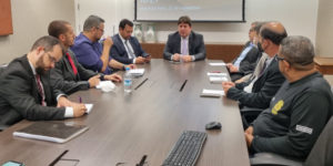Representantes do SINJUS, Alexandre Pires e Felipe Rodrigues, do Serjusmig, do Sindojus/MG e da Administração do TJMG sentados à mesa de reunião.