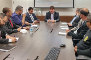 Representantes do SINJUS, Alexandre Pires e Felipe Rodrigues, do Serjusmig, do Sindojus/MG e da Administração do TJMG sentados à mesa de reunião.